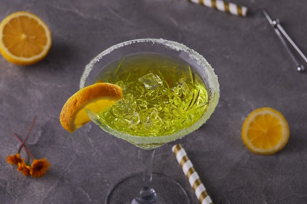 Liqueur de thé au citron dans un verre à martini sur une table grise