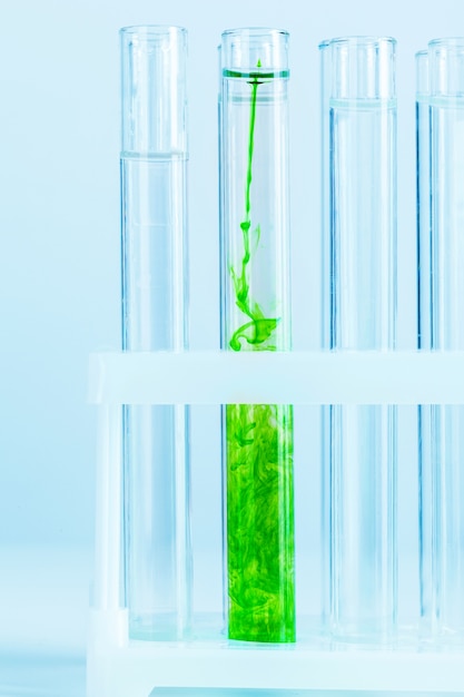 Liquides verts dans des éprouvettes en laboratoire chimique se bouchent