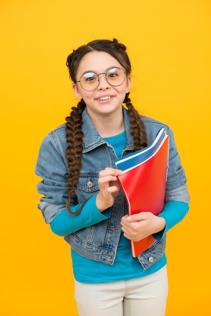 Lire de bons livres pour grandir Un enfant heureux tient des livres sur fond jaune Lecteur de bibliothèque Apprendre à lire Lecture à domicile Retour à l'école Littérature et langue Fantaisie et imagination Lire de temps en temps