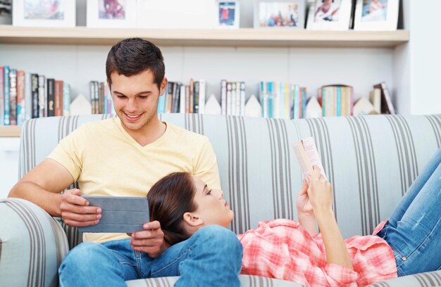 Lire ensemble Un jeune couple se détendre à la maison sur le canapé