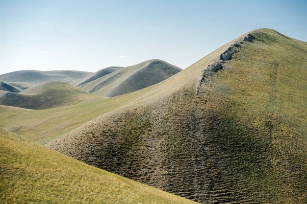 Lisse belle crête de colline herbeuse allant tout au long de la distance. Paysage à voir. Terre, pliée par la tectonique des plaques.