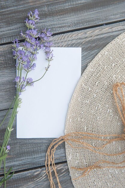 Liste blanche de l'espace vide avec des fleurs de lavande et un chapeau de soleil sur un fond en bois de style ancien, vue de dessus