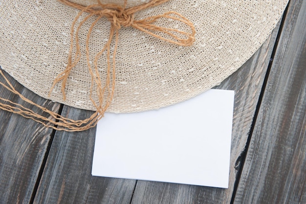 Liste blanche vide avec des fleurs de lavande et un chapeau de soleil sur un fond en bois