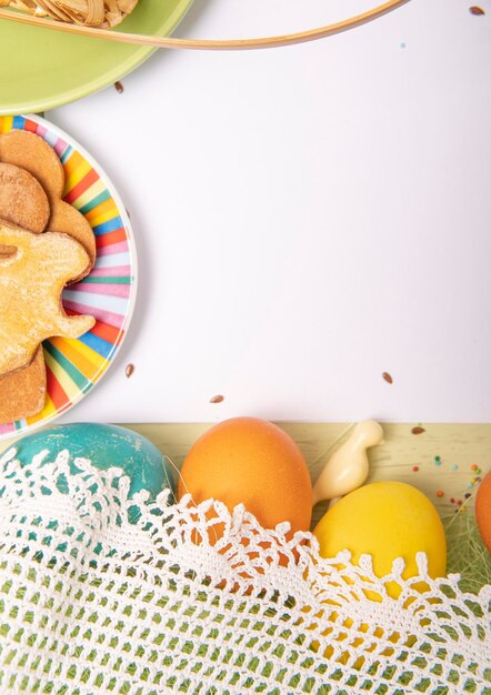 Liste vide blanche sur fond de Pâques avec des oeufs colorés et des biscuits faits maison