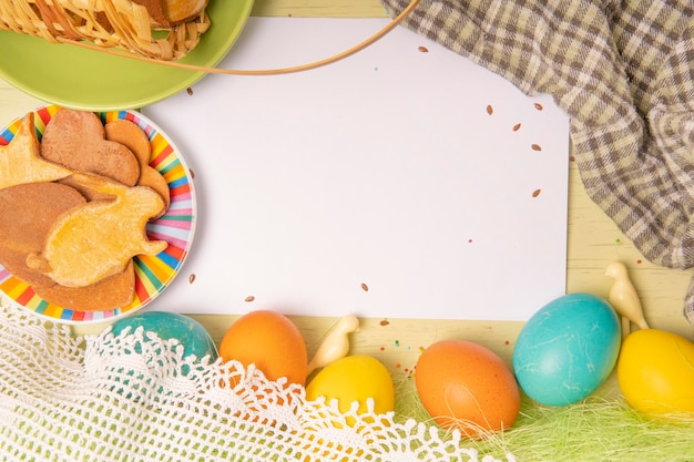 Liste vide blanche sur fond de Pâques avec des oeufs colorés et des biscuits maison de vacances