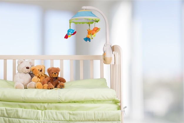 Lit bébé avec des jouets en arrière-plan