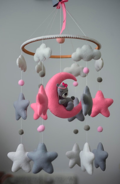 Un lit de bébé mobile, un jouet musical suspendu au-dessus du berceau de bébé, un ours de rêve dans l'espace lunaire, un lit de bébé en feutre mobile.