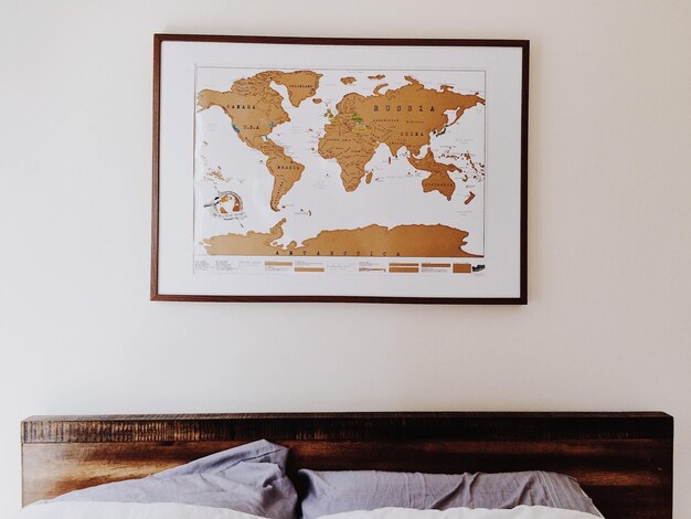 Photo le lit contre la carte du monde sur le mur à la maison