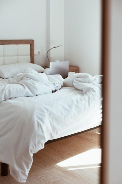 Un lit en désordre vu depuis la porte
