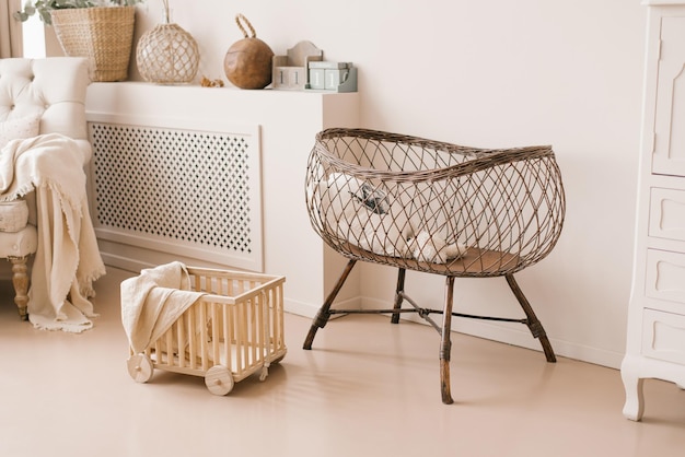 Lit en osier pour bébés pour bébés à l'intérieur de la chambre des enfants dans des tons beige clair