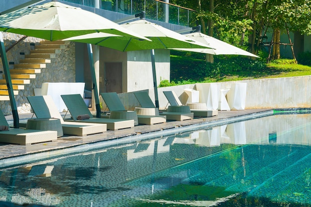 Lit piscine avec parasol autour de la piscine - Concept de vacances et de vacances