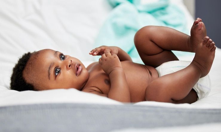 Photo lit de relaxation et bébé noir avec couche dans la pépinière pour le développement de la croissance et la curiosité dans l'enfance à la maison calme et petit bébé avec étonnement sur la couverture pour le confort le bien-être et le repos dans la maison