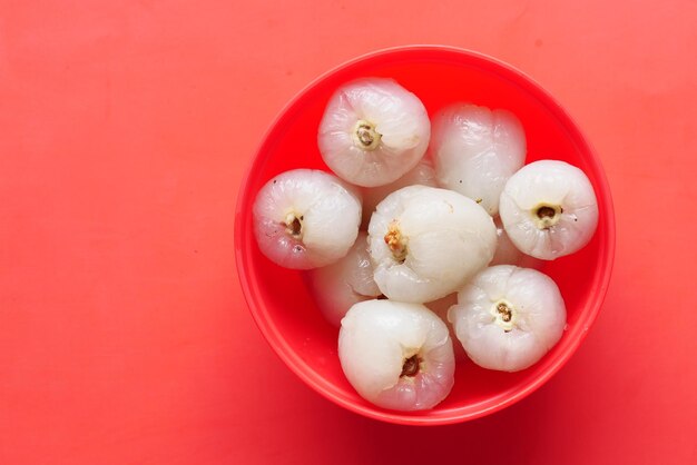 Litchi sur dans un bol sur fond rouge