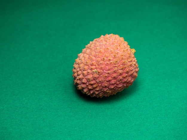 Litchi sur la table Prune chinoise sur fond vert Fruits mûrs d'Asie Délicieux produit juteux