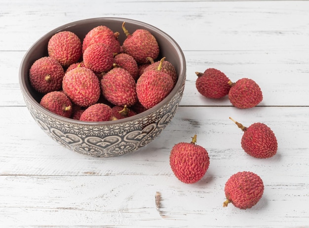 Litchis dans un bol sur une table en bois.