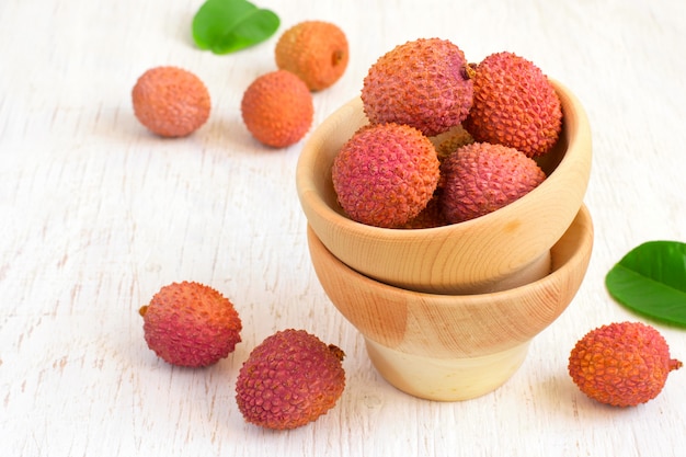 Litchis mûrs dans un bol sur un fond blanc, copiez l'espace