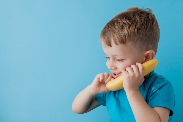 Little Boy essaie de parler au moyen d'une banane au lieu d'un téléphone.