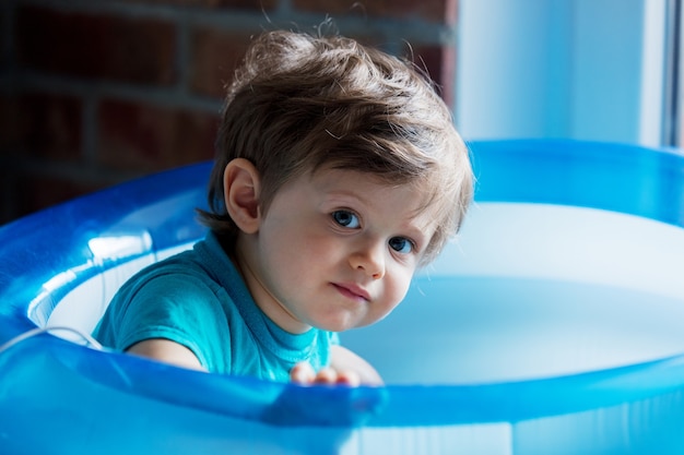 Little Toddler est joué dans une piscine gonflable