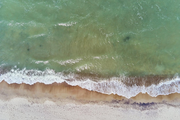 Littoral avec vagues de la mer bleue et vue de dessus de plage de sable