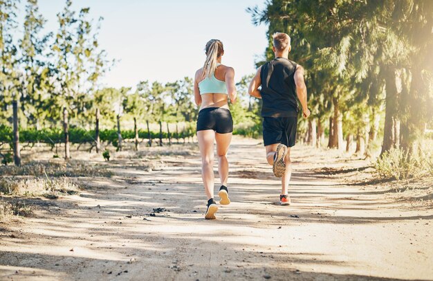 Live Love Run Vue arrière d'un jeune couple courant ensemble à l'extérieur