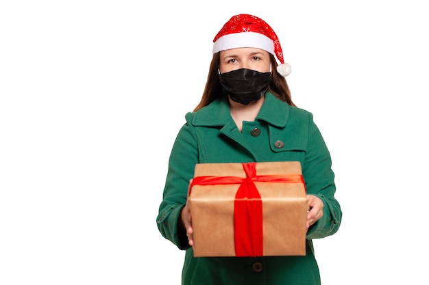 Livraison d'un cadeau de Noël à domicile avec masque médical. Livraison de cadeaux pour Noël isolé sur blanc