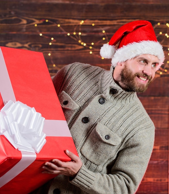 Livraison de cadeaux à domicile homme heureux avec barbe bonnet de noel présent pour vous seulement mon offre avantageuse de réductions d'hiver ventes de achats de noël quelle surprise cadeau de nouvel an homme hols énorme cadeau