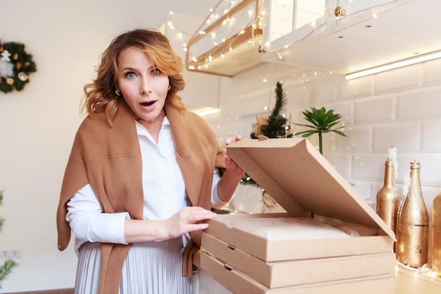 Livraison à domicile. L'hôtesse mange une tarte pour le dîner de Noël. Les vacances du nouvel an