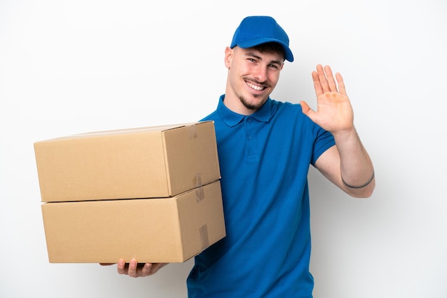 Livraison homme caucasien isolé sur fond blanc saluant avec la main avec une expression heureuse