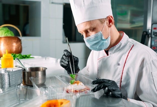 Livraison de nourriture au restaurant. Le chef prépare la nourriture au restaurant et l'emballe dans des plats jetables.