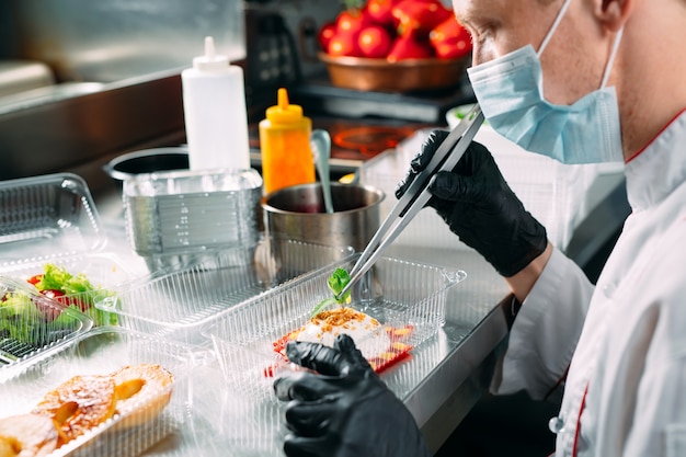 Livraison De Nourriture Au Restaurant. Le Chef Prépare La Nourriture Au Restaurant Et L'emballe Dans Des Plats Jetables.