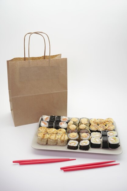 Photo livraison de nourriture japonaise, ensemble de sushis et emballage artisanal sur un fond isolé