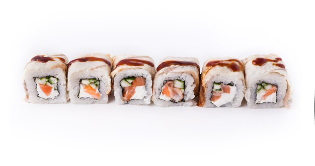 Livraison de nourriture de restaurant japonais sain. Ensemble de rouleaux de saumon et d'anguille avec fromage à pâte molle et sauce unagi isolé sur fond blanc, gros plan.