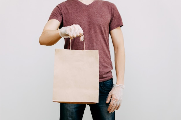 Livraison de nourriture sans contact par un coursier masqué et ganté dans un magasin ou un restaurant.