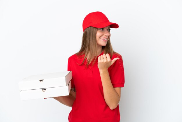 Livraison de pizza femme lituanienne isolée sur fond blanc pointant vers le côté pour présenter un produit