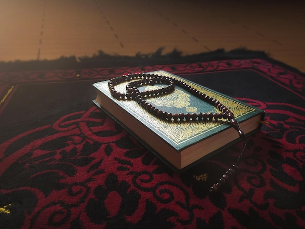 Livre d'Al Quran Al Karim avec un fond de tapis de prière Concept de Ramadan