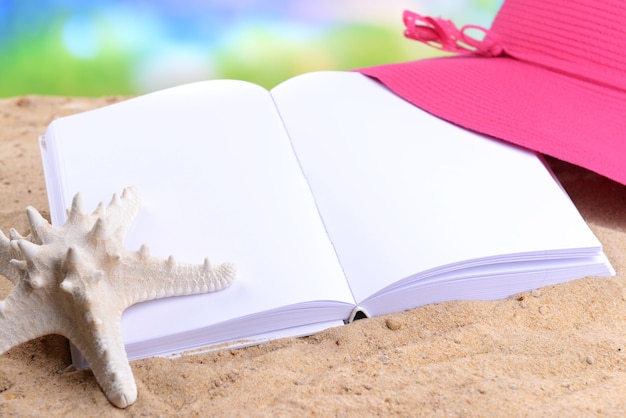 Livre blanc ouvert sur fond de sable