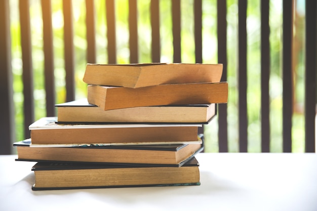 Photo livre sur le bureau dans la salle de la bibliothèque près de la fenêtre avec flou pour fond, éducation