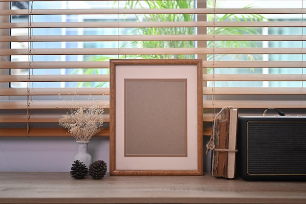 Livre de cadre photo en bois vide et haut-parleur sans fil sur une table en bois dans le salon