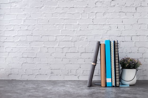 Livre et cahier papier sur le mur de briques de la maison.