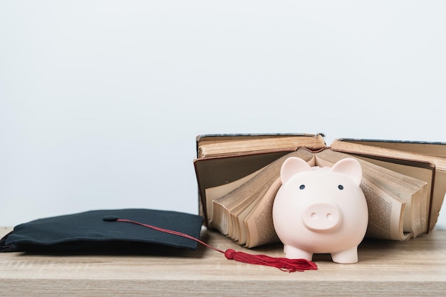 Livre de chapeau de graduation noir et concept de tirelire investissement dans l'éducation Graduation économiser de l'argent pour l'éducation