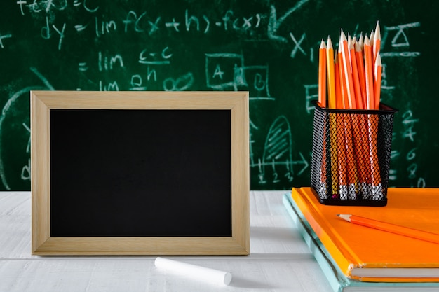 livre et un crayon sur le tableau blanc tableau noir avec un bureau