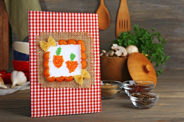 Livre de cuisine conçu avec des ingrédients alimentaires sur la table de la cuisine en gros plan