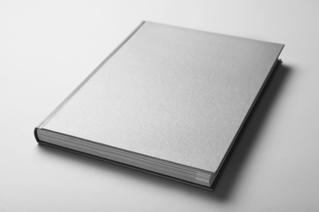 Livre gris fermé avec couverture rigide sur fond blanc