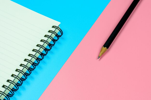 Livre de journal intime et un crayon sur fond bleu et rose avec copie espace. - vue de dessus.