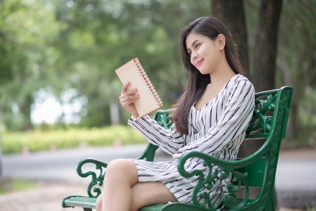 Livre de lecture de belle femme dans le parc vert