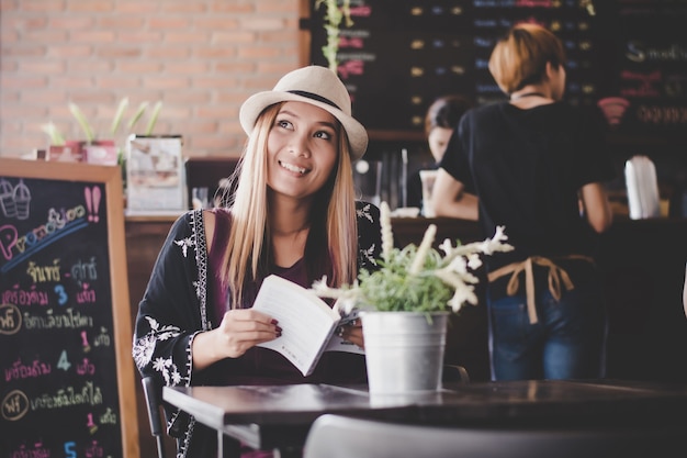 Livre de lecture de femme d&#39;affaires heureuse en se détendant au café.