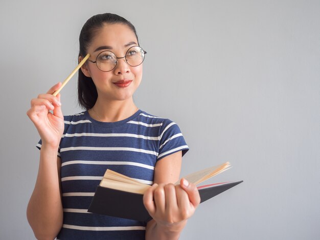 Livre de lecture de femme asiatique et de réflexion pour des idées.