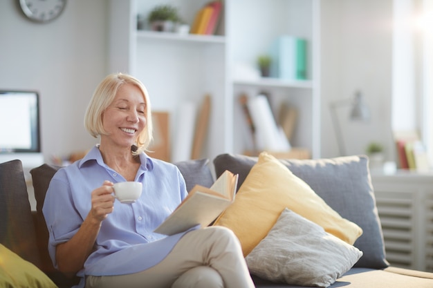 Livre de lecture de femme mature à la maison