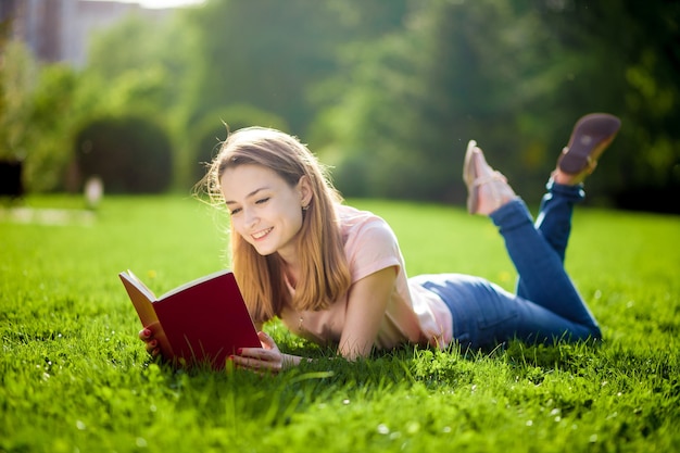 Livre de lecture fille allongé sur la pelouse