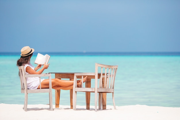 Livre de lecture de jeune femme pendant la plage blanche tropicale